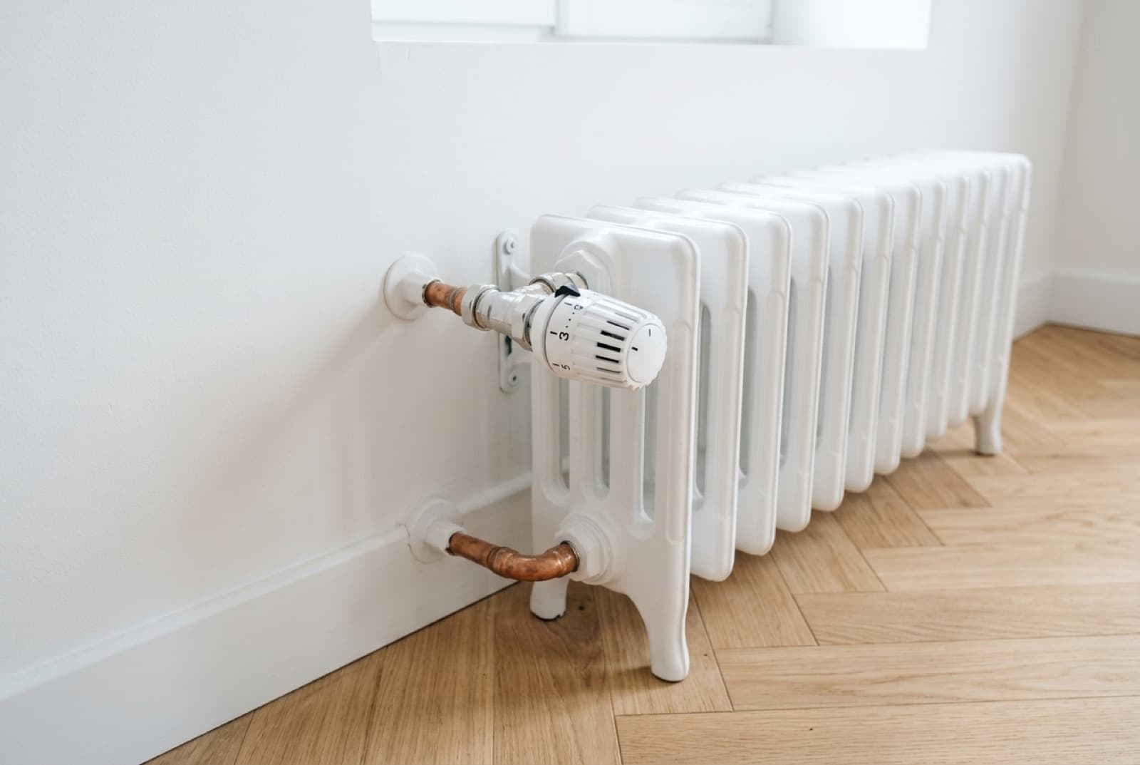 Radiateur en fonte ancien dans une maison de village, robinet thermostatique en gros plan