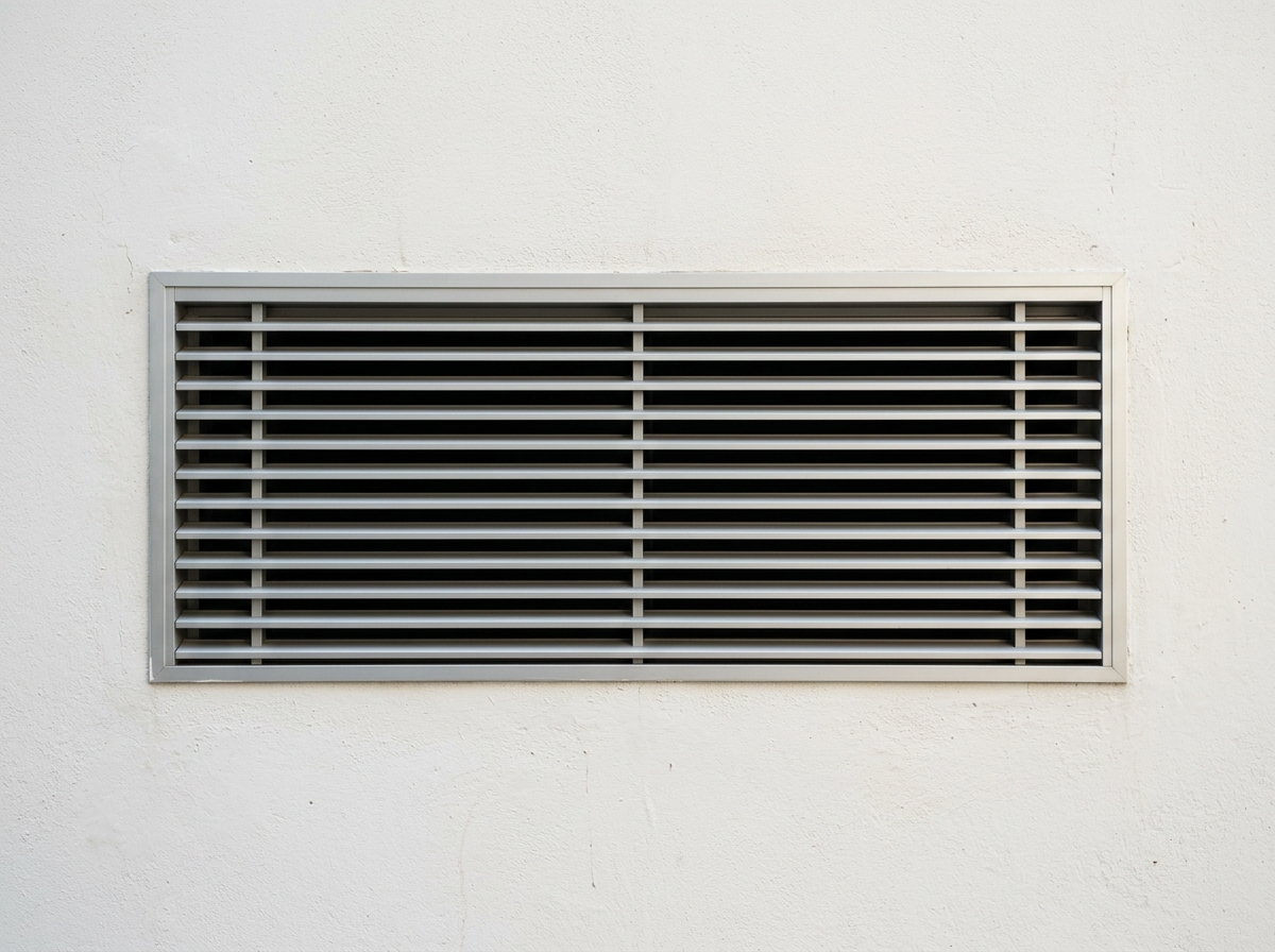Gros plan sur une grille de ventilation moderne encastrée dans un mur